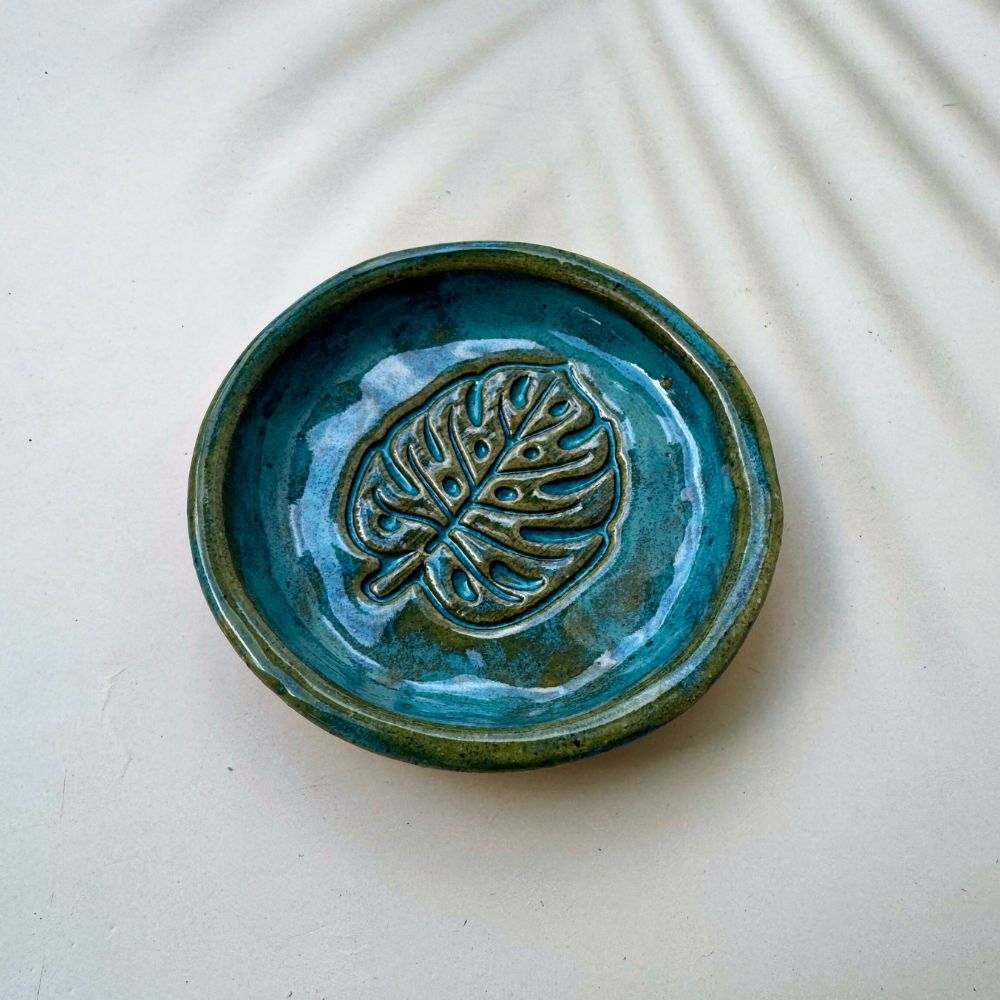 Blue ceramic dish with leaf design on a white background