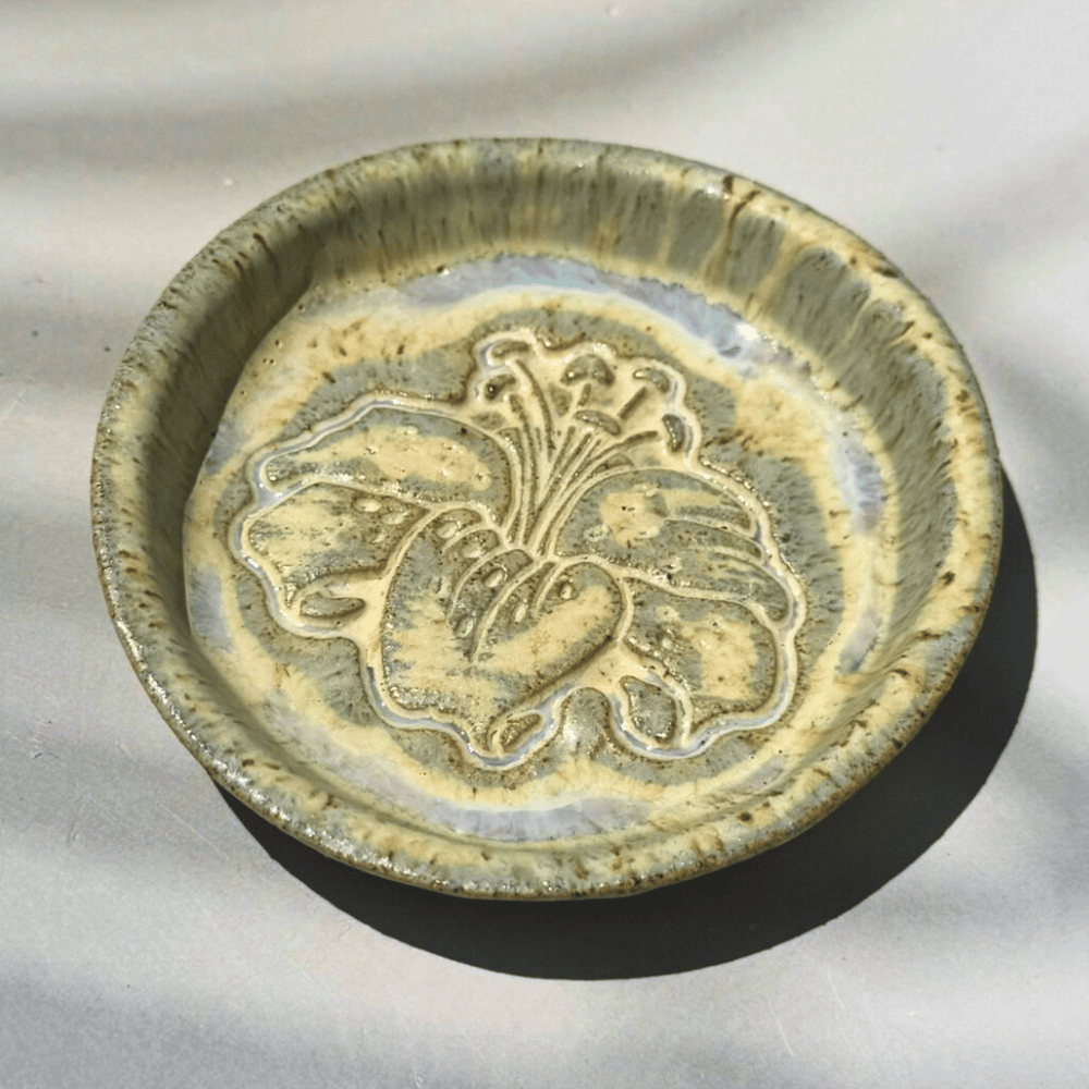 Ceramic ring dish with floral design on a light gray background