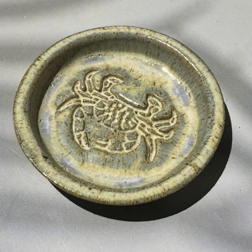 Ceramic trinket dish with a crab design on a gray background