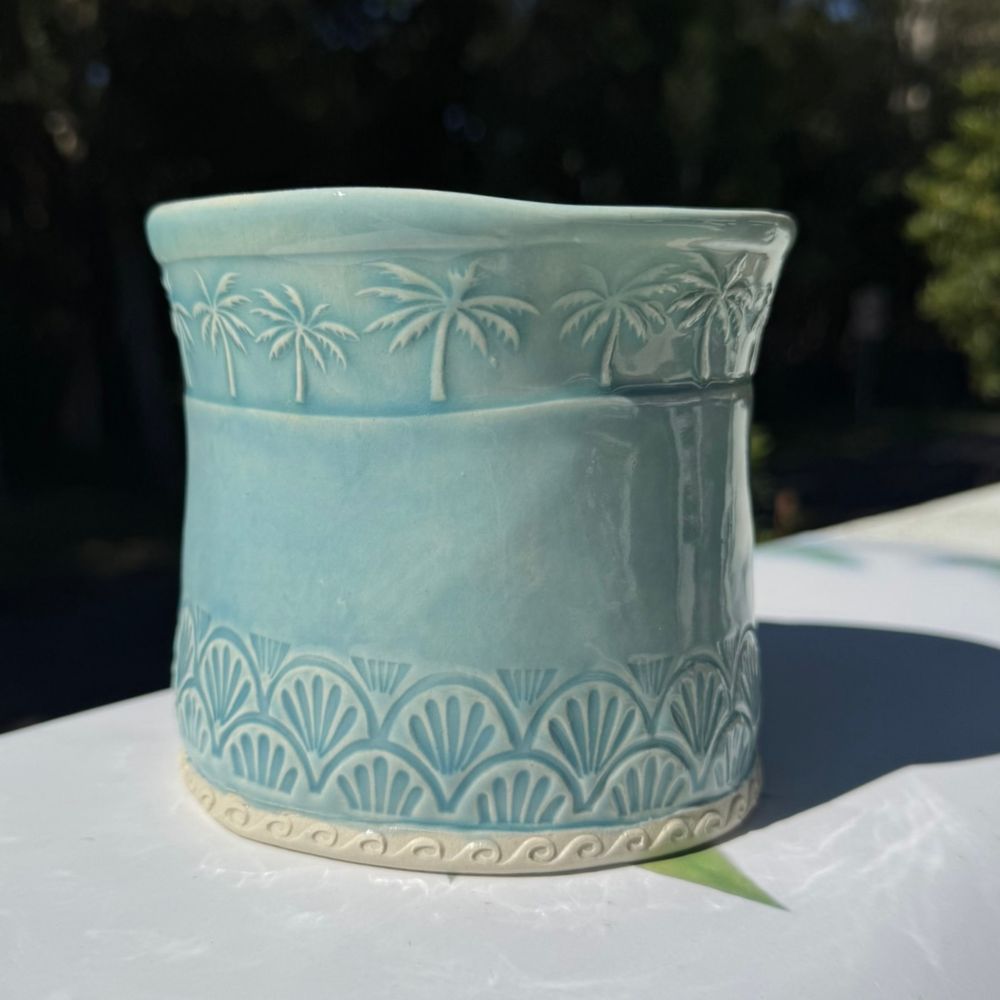 Ceramic planter with decorative patterns on a white surface