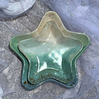 Star-shaped green ceramic dish on a textured surface
