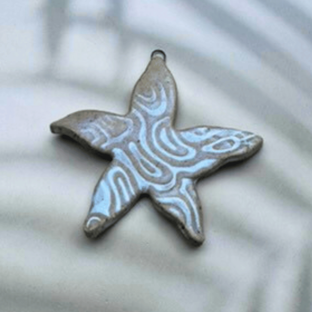 Star-shaped ceramic pendant on a light background
