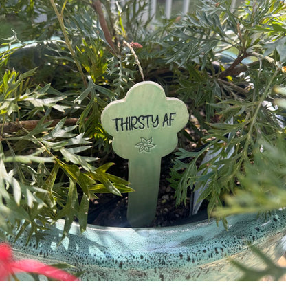 Green plant stake with 'THIRSTY AF' text on a white background