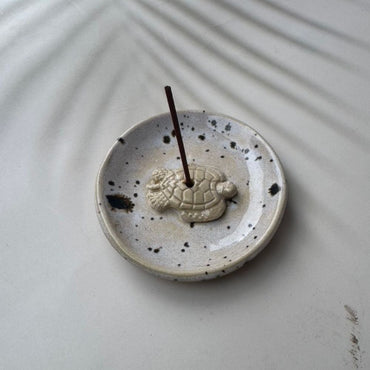 Ceramic incense holder with turtle design on a light gray surface