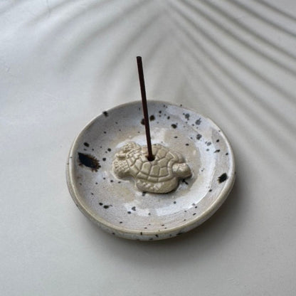 Ceramic incense holder with turtle design on a white surface