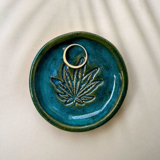 Ceramic dish with leaf design on a beige background