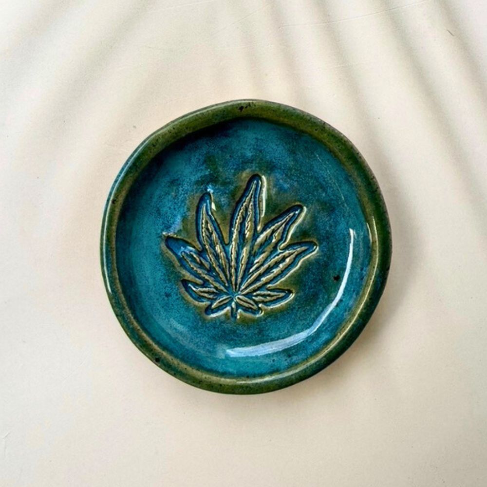 Blue ceramic dish with a leaf design on a beige background