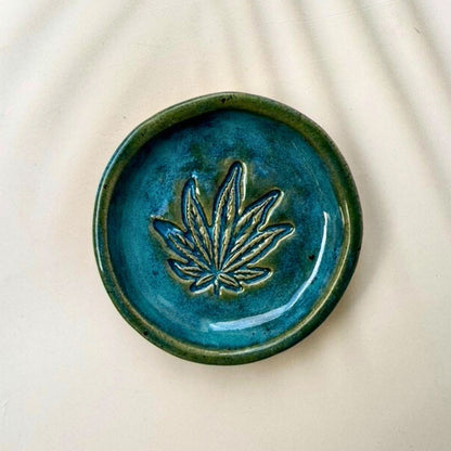Blue ceramic dish with a leaf design on a beige background